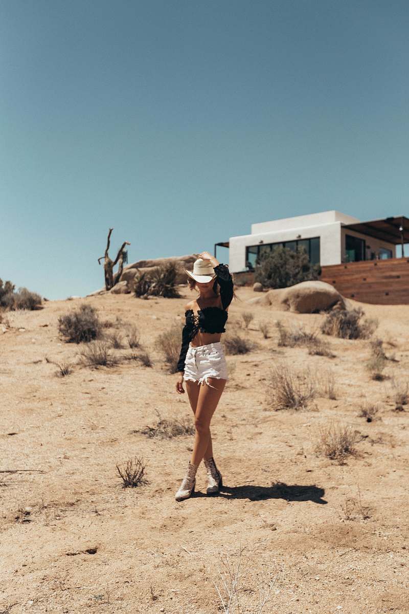 desert woman wearing black long-sleeved shirt and white shorts outside white building united states